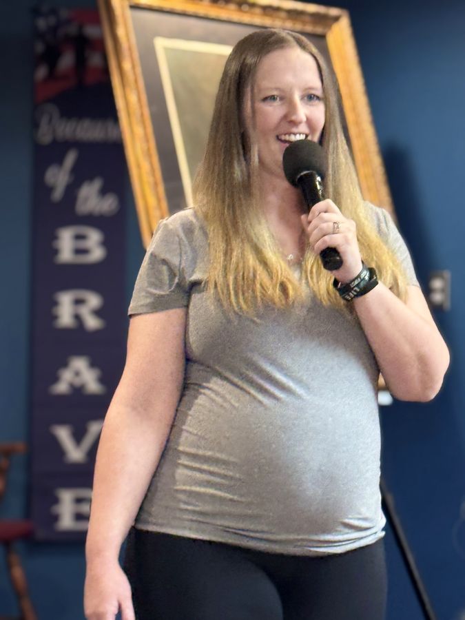 Rebecca Winegar speaking with a microphone at the Lincoln Club Luncheon, May 2026